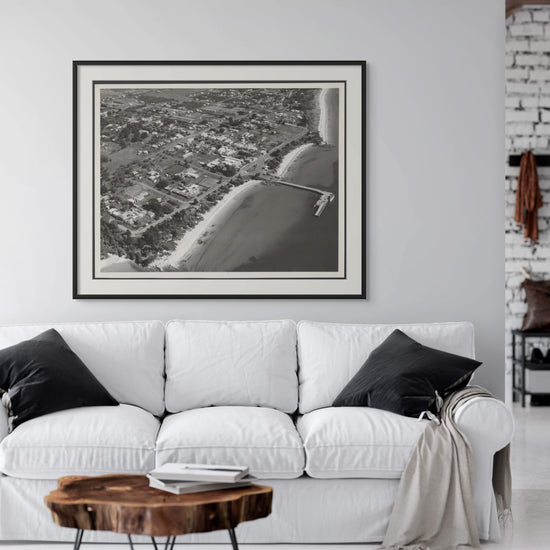 Stunning vintage aerial photograph of Phillip Island from the 1950s, captured in black and white. This captivating print reveals a nostalgic view of the island's landscape, showcasing its charming coastal features and expansive natural beauty.